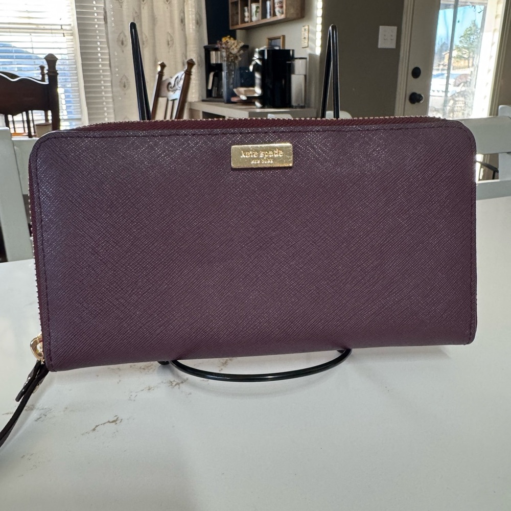 This is a Kate Spade Neda Laurel Way zip-around wallet in deep plum